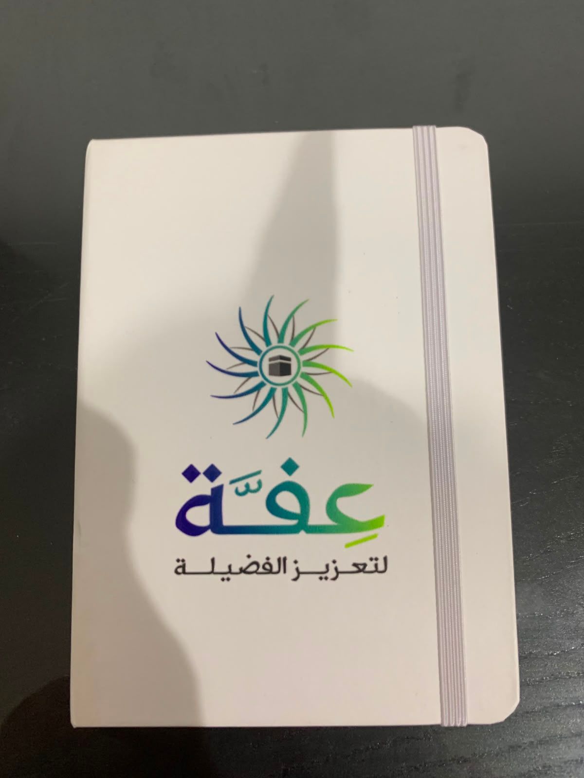 دفتر أبيض بغلاف صلب مطبوع بشعار جمعية غير ربحية