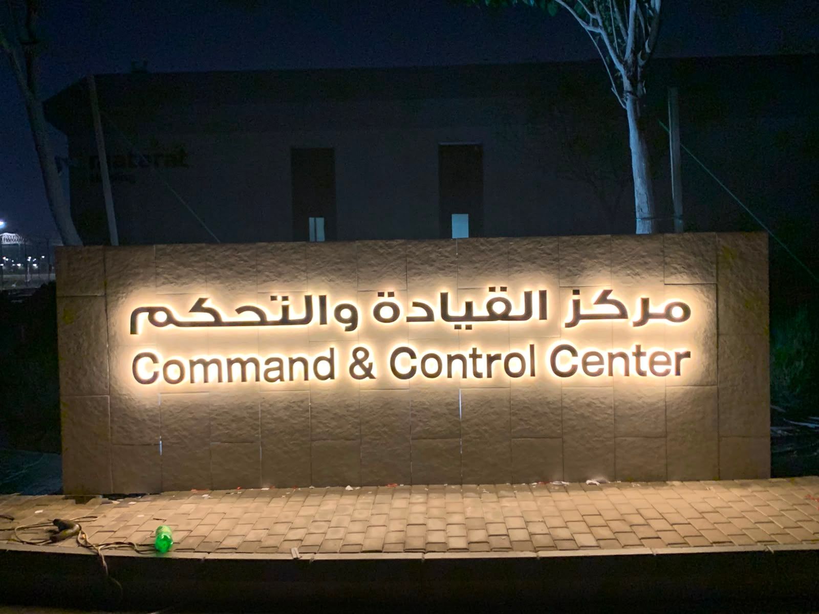 حروف مضيئة من الخلف لمركز تحكم تشغيلي على جدار حجري ليلًا، جدة