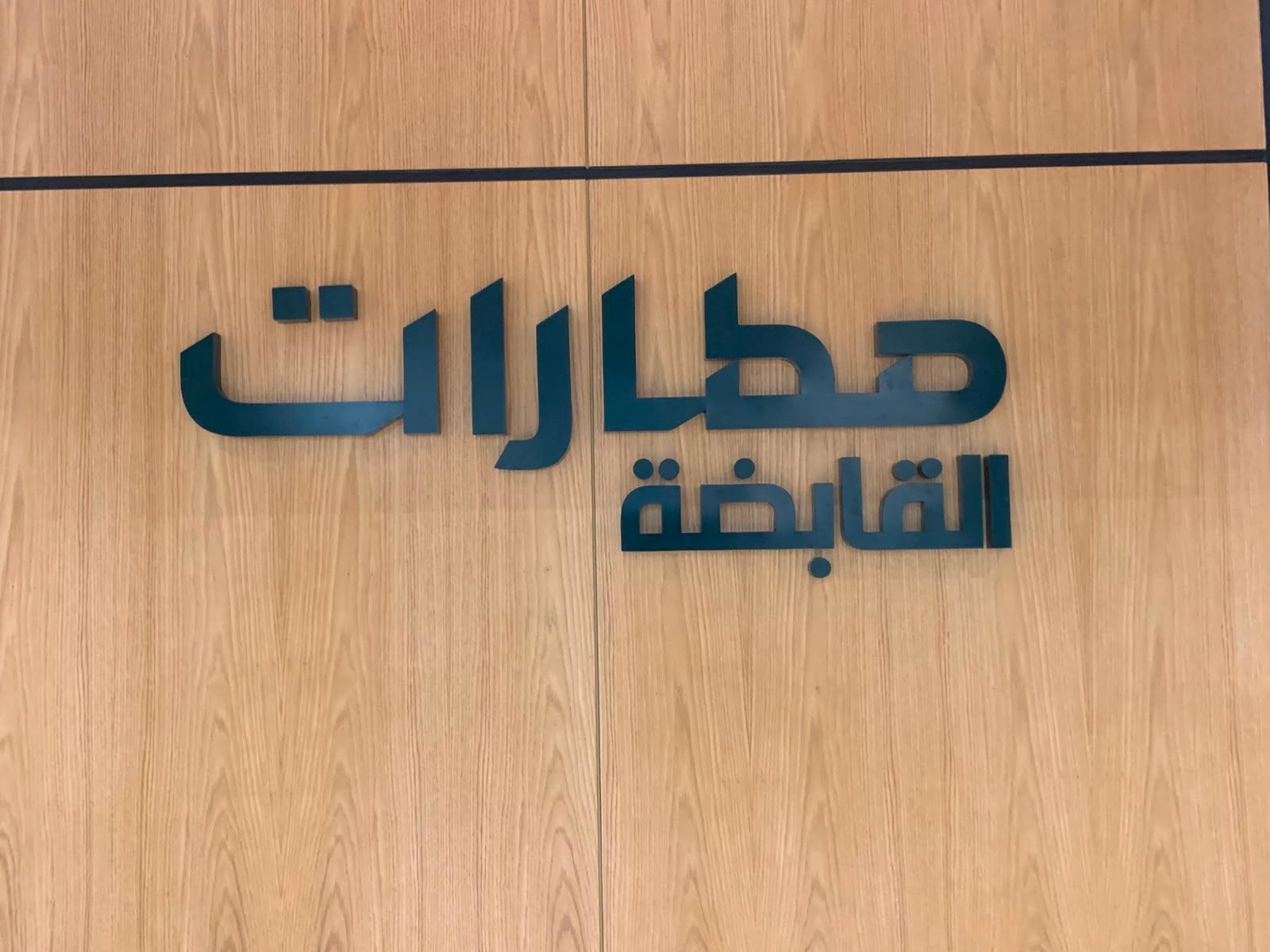 حروف عربية بارزة على جدار من قشرة البلوط في مكتب شركة قابضة، جدة