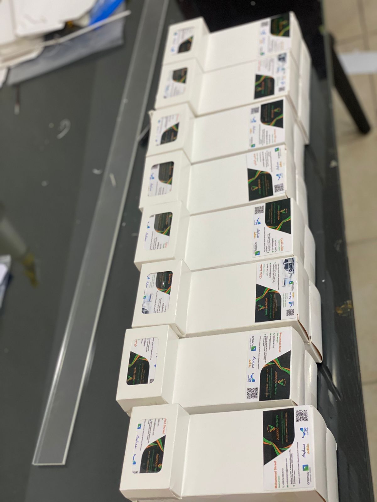 صف من علب منتجات بيضاء صغيرة مطبوعة برموز QR