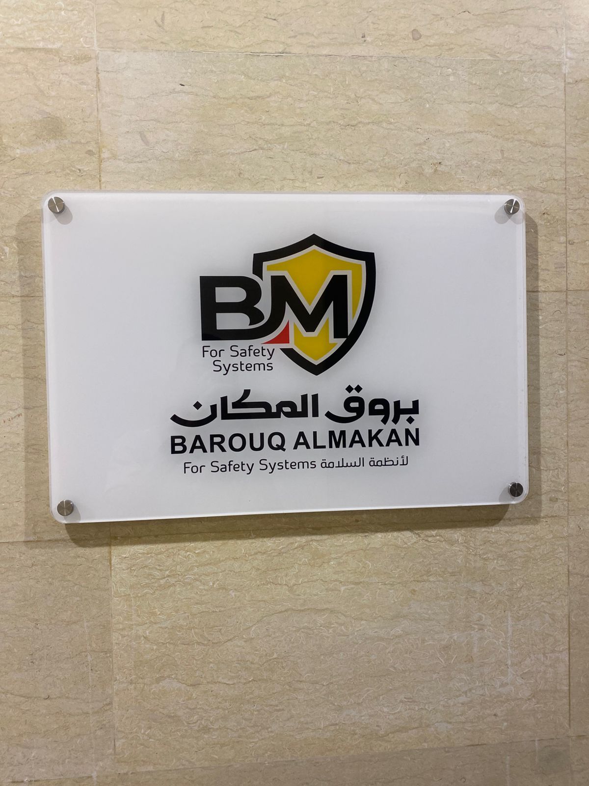 لوحة أكريليك بيضاء لشركة أنظمة سلامة على جدار حجري، جدة